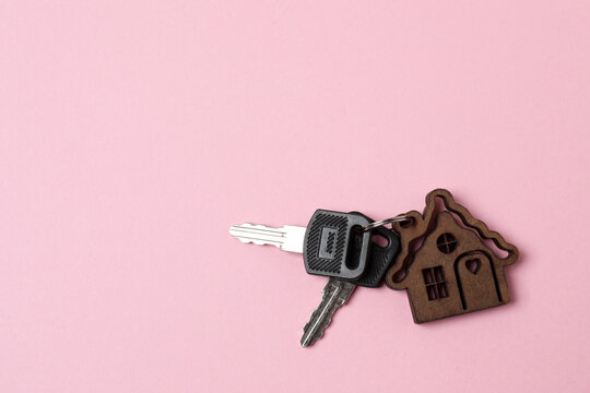 Apartment keys with a house-shaped keychain on a colorful background.
