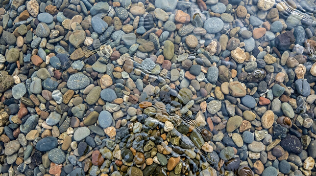 River stones underwater. Natural pebbles submerged in a clear mountain stream.