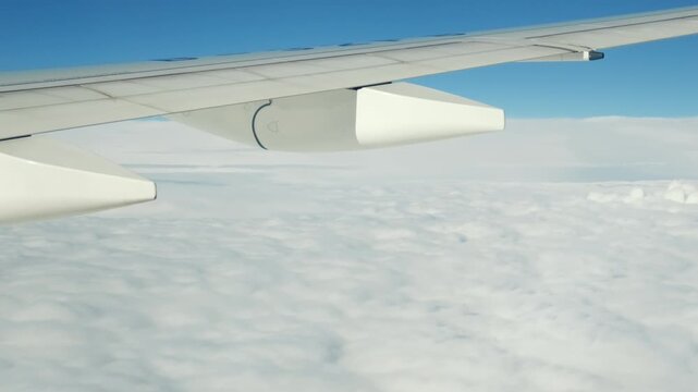 Plane wing above clouds, travel and flight by airplane, aerophobia and aviation. Summer vacation or business trip, amazing beautiful cloudscape in blue sky, dream of flight and traveling by aircraft