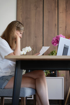 Worried woman reading a household bill at home