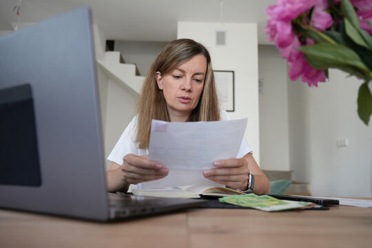 Woman checking household bills and expenses at home