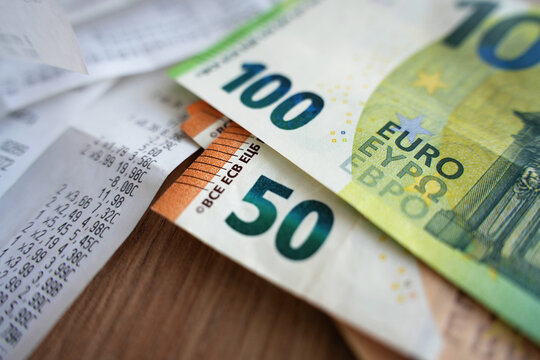 Euro banknotes and shopping receipts on table