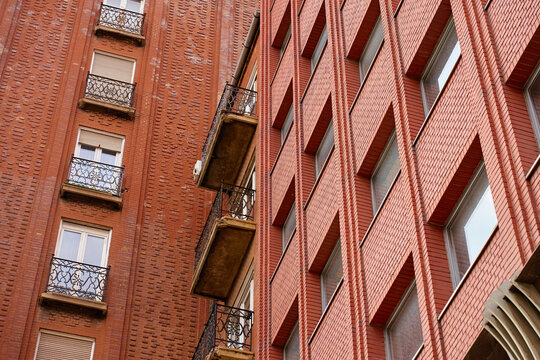 Red brick apartment building facades with balconies and windows