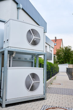 Two Outdoor Heat Pump Units Installed Beside Residential Building