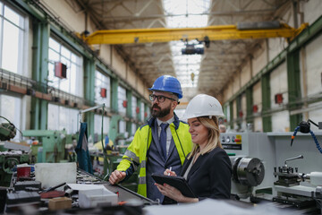 Fototapeta premium Factory manager and mechanic worker talking industrial factory.