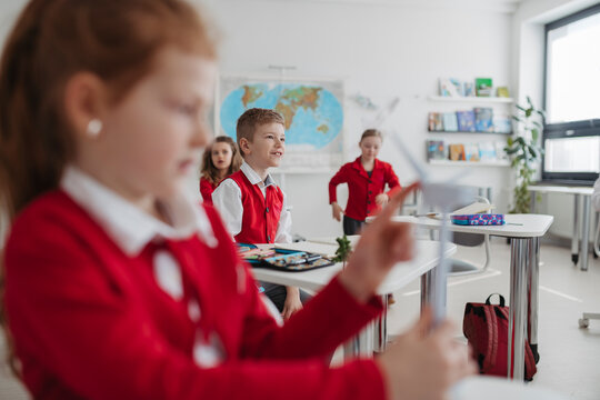 Teacher teaching primary school students about renewable wind energy.