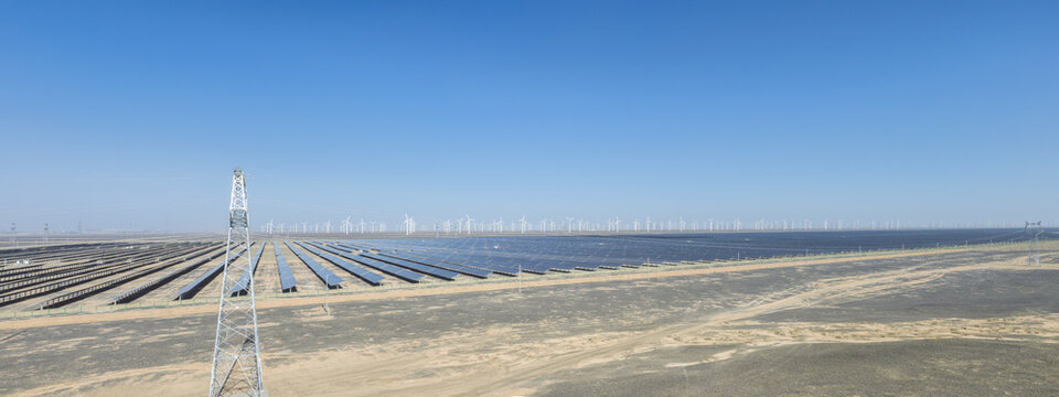 Expansive Solar And Wind Farm With Transmission Tower In Desert