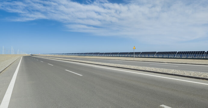 Empty Desert Highway Along Solar Farm In Dunhuang