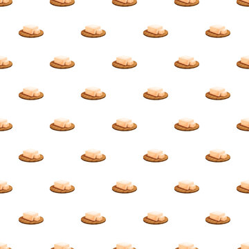Butter blocks sitting on crackers in an all over repeating pattern on white background