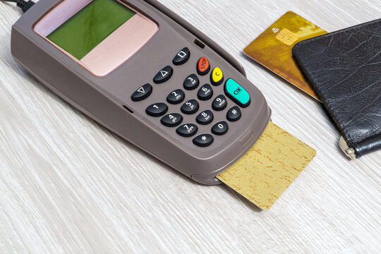 Electronic payment terminal machine with a inserted chip card and wallet on a light table terminal financial