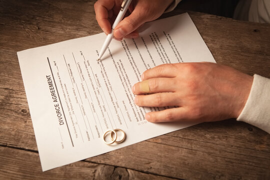Wedding rings on a contract and a man signing a document