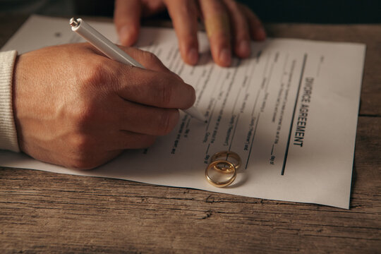 Wedding rings on a contract and a man signing a document