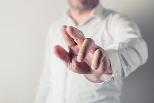Businessman in white shirt pointing with his finger at empty copy space.