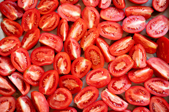 Red halved tomatoes as background