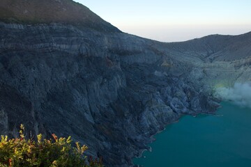 Ijen volcano crater with turquoise volcanic lake and rugged cliffs © Paul