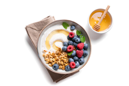 Granola bowl with greek yogurt, berries and honey for healthy breakfast.