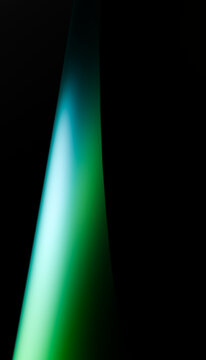Green and blue gradient light beam against dark background