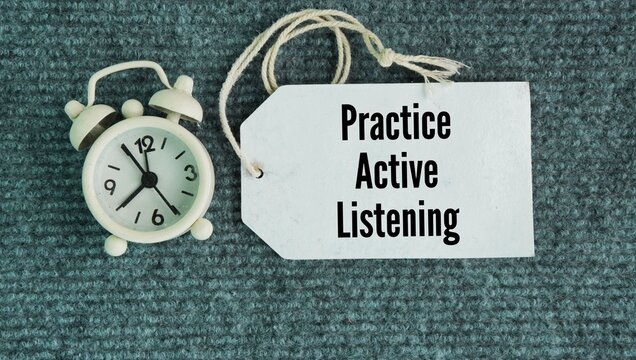 Chimes and paper tags with the words Practice active listening. giving a speaker your full, undivided attention, understanding their message, and responding with genuine intent rather than just waitin