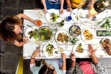 Obraz premium Diverse women sharing a colorful overhead lunch at a table