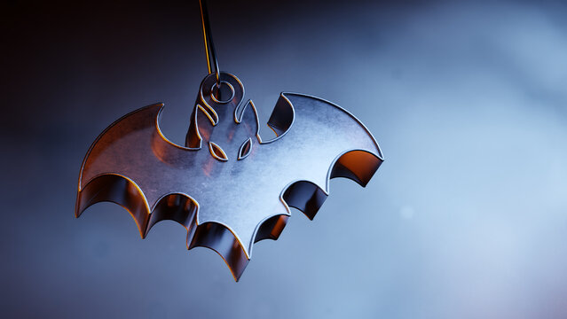 Metallic Halloween bat ornament hanging on a dark misty background.
