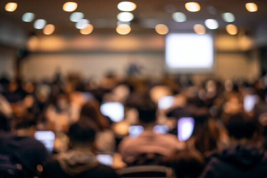 Completely blurred background Defocused Audience in Modern University Auditorium with Laptop Screens and Presentation Display, Blurred Business Education Seminar and Conference Background