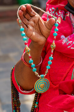 Nepal. Kathmandu. A woman displays a traditional Ghau necklace adorned with turquoise beads and an intricately carved pendant, typical of Nepalese craftsmanship