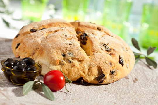 Loaf of bread with olive and tomato, close up