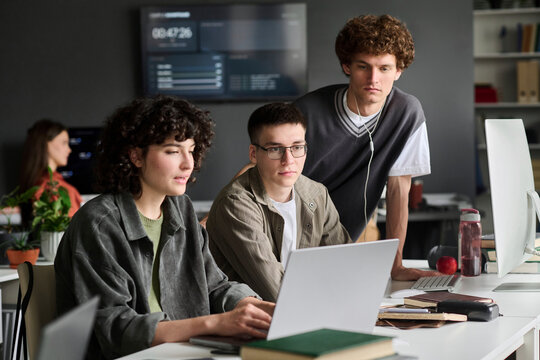 A student team works on a digital task using a laptop indoors