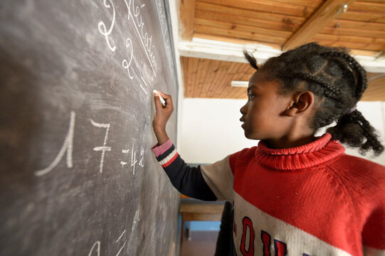 Madagaskar, Girl in Fianarantsoa elementary school calculatiing at blackboard