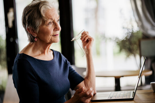 Woman enjoying coffee and using laptop at caf� with a happy expression