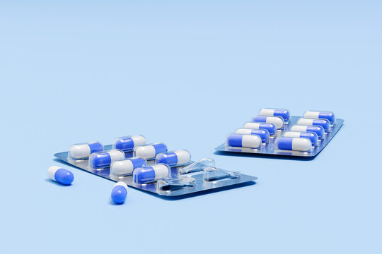 Blue and white medical capsules in blister pack on blue background