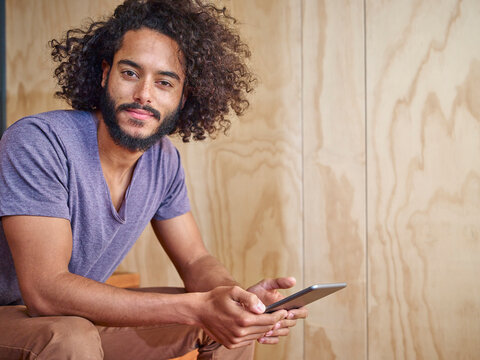 Portrait of young man holding digital tablet