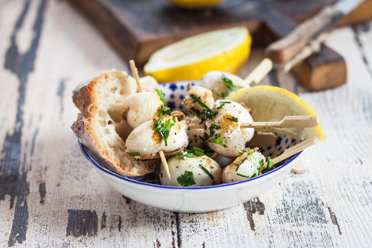 Tapas, grilled sepia, lemon and bread in bowl
