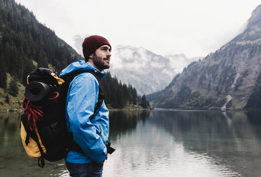 Austria, Tyrol, Alps, hiker standing at mountain lake