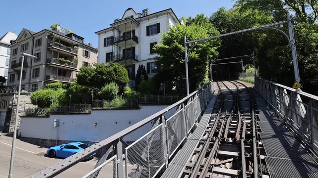 View of the historic Polybahn funicular railway tracks ascending towards residential buildings in Zurich, Zurich, Switzerland.