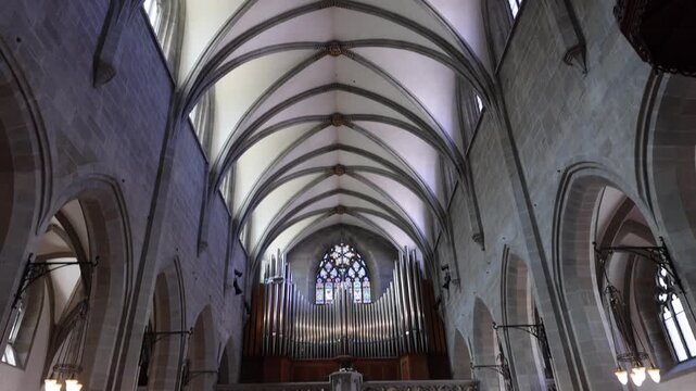 View of the Fraumunster church interior featuring the grand pipe organ, wooden pews, and stone arches in Zurich, Zurich, Switzerland.