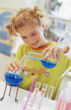Girl (8-9) in chemical lab, smiling