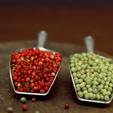 Red and green peppercorns in scoop, close-up