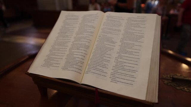 View of an open Bible resting on a wooden lectern inside the historic Grossmunster church in Zurich, Zurich, Switzerland.