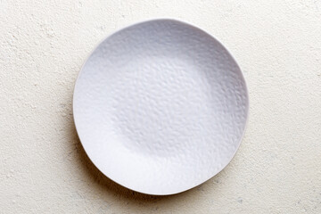 Top view of empty light plate on cement background. Empty space for your design