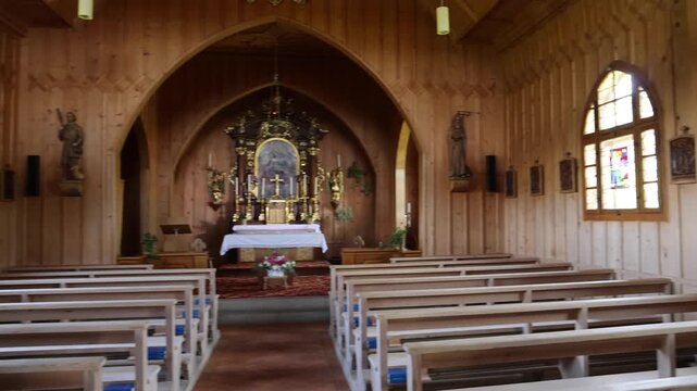 View of the wooden interior of a chapel with pews and an altar in Schwyz, Schwyz, Switzerland.
