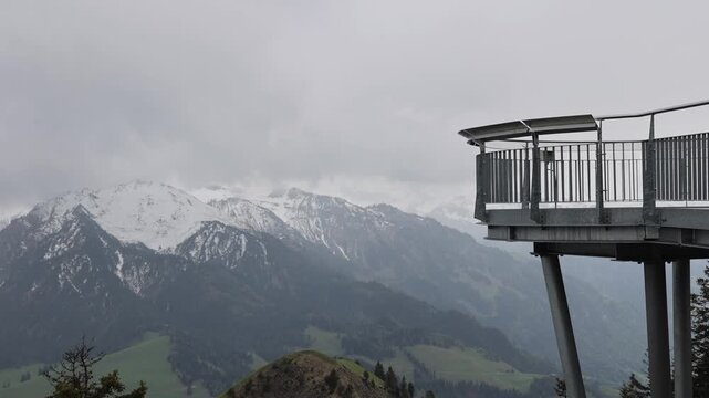 View of the Stanserhorn-Bahn viewing platform overlooking snow-capped mountain peaks and green valleys in Stans, Nidwalden, Switzerland.