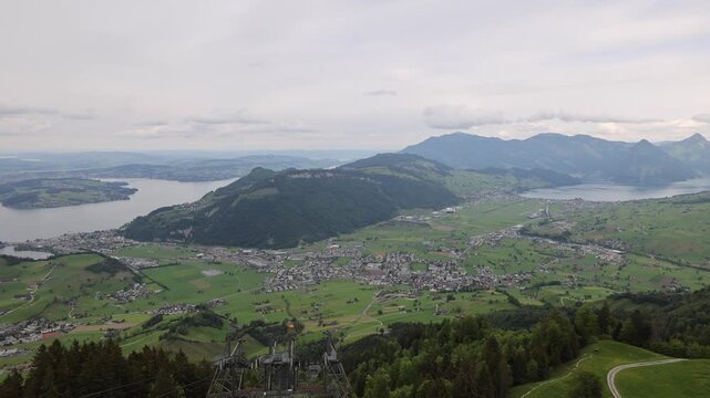 View of Stanserhorn-Bahn cable car infrastructure overlooking the town of Stans and the surrounding valley with Lake Lucerne in the distance, Stans, Nidwalden, Switzerland.