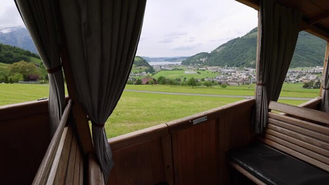View of the Stanserhorn-Bahn cable car interior looking out over the green meadows and town of Stans, Nidwalden, Switzerland.