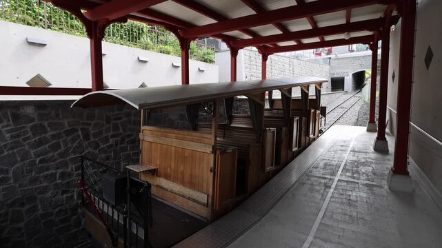 View of the historic wooden Stanserhorn-Bahn funicular train parked at the station platform in Stans, Nidwalden, Switzerland.