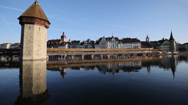 View of the historic Chapel Bridge and Wasserturm spanning the Reuss River with traditional architecture in the background in Lucerne, Lucerne, Switzerland.