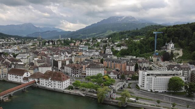 View of the historic city of Lucerne with the Reuss river and the Chapel Bridge under a cloudy sky in Lucerne, Lucerne, Switzerland.