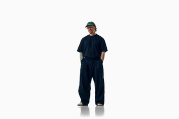 Stylish man in oversized black outfit stands full-body isolated on white. Concept of minimalist menswear, personal style, relaxed confidence and modern street fashion. © Lustre Art Group 