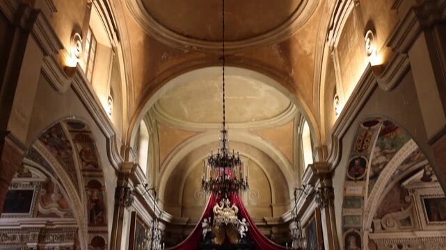 View of the ornate altar with red drapery and religious statues inside the historic Church of Santa Maria del Sasso in Morcote, Ticino, Switzerland.