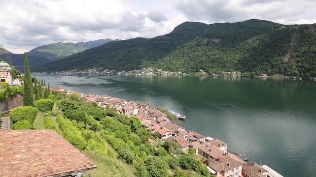 View of the historic village of Morcote with stone houses nestled along the shores of Lake Lugano in Morcote, Ticino, Switzerland.